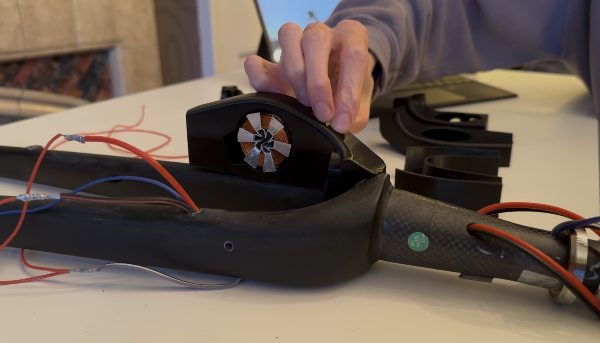 PETG shroud on the carbon fork before final epoxy bonding, electromagnet embedded and wired